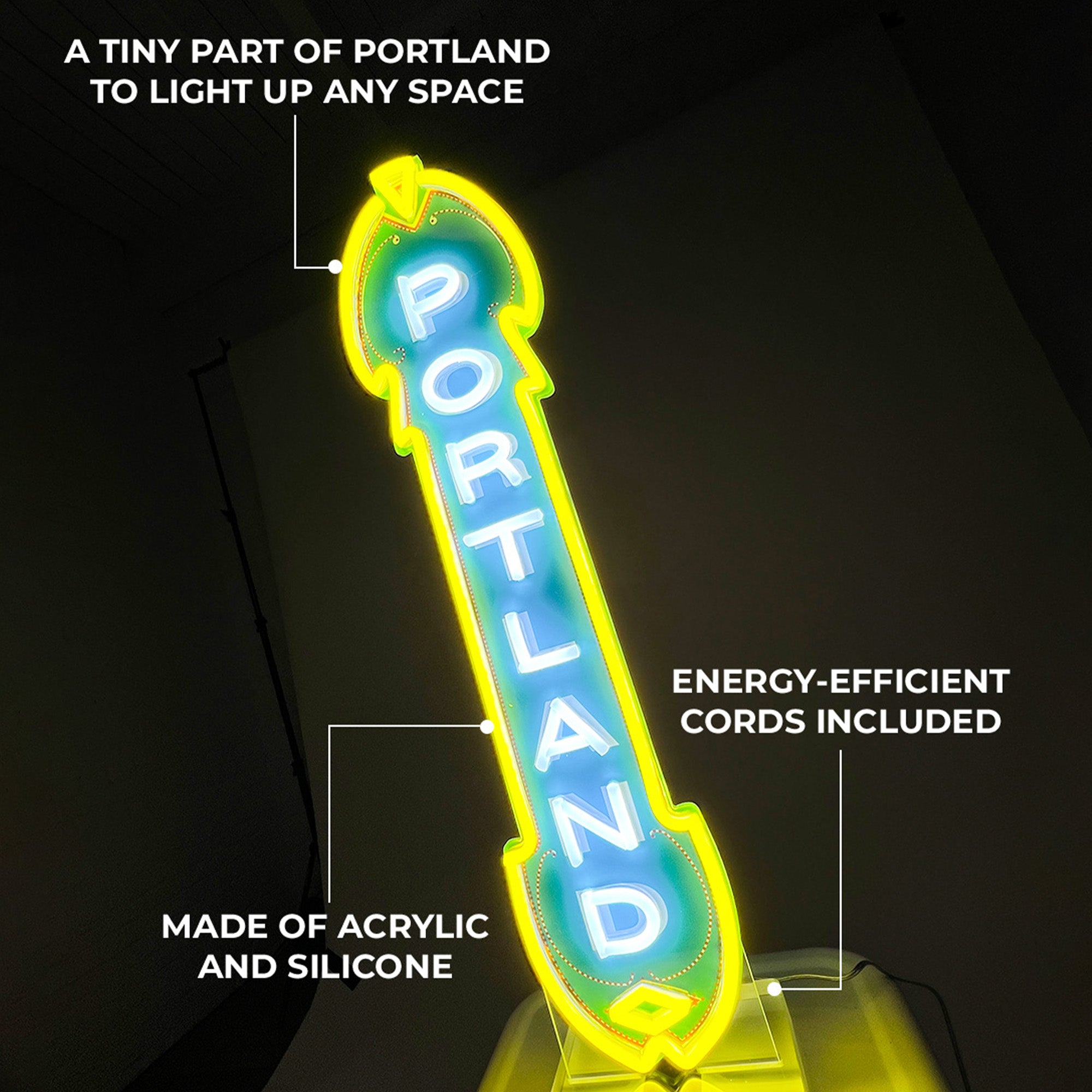 A LED Marquee Sign displaying the word "PORTLAND" in vibrant green and yellow hues set against a dark backdrop. Text annotations highlight the sign's attributes: "A tiny part of Portland to light up any space," "Energy-efficient cords included," and "Made of acrylic and silicone." This custom LED sign injects eco-friendly brilliance into any room with its stylish design.