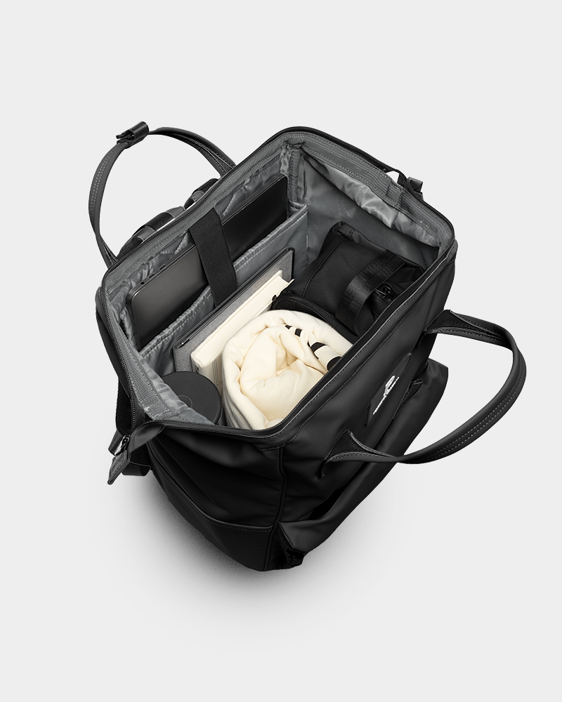 Black backpack with a white hoodie inside on a light gray background