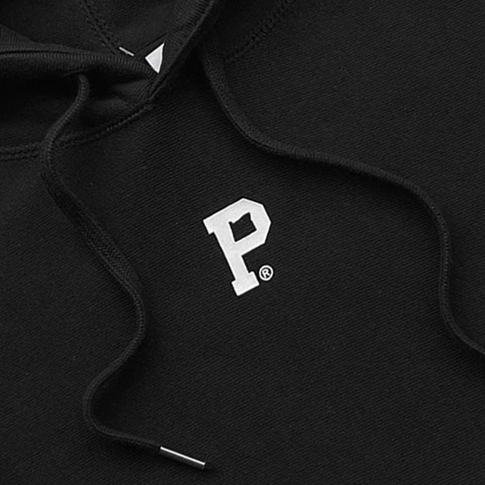 Close-up of the HeavyKnit Centerpiece Hoodie - Black, featuring a high density white "P" logo embroidered on the heavyweight fabric. The hoodie also boasts adjustable drawstrings with metal tips near the neckline. Set against a dark background that accentuates its minimalist design, this hoodie arrives in sustainable packaging.