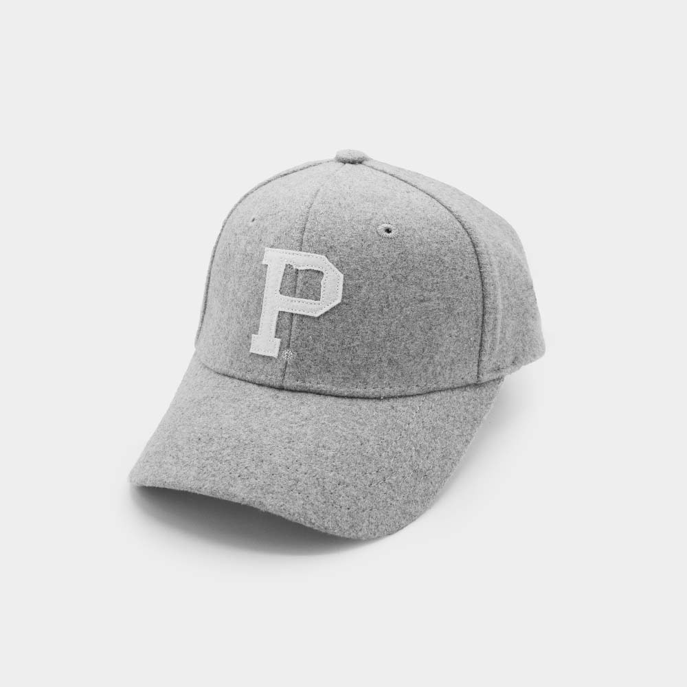 The Portland "P" Cap - Classic is a vintage strap hat featuring a gray baseball cap with a white embroidered letter "P" on the front. Made of soft, wool-like material, it boasts a slightly curved bill and is shown placed on a light gray surface, angled slightly to the right.