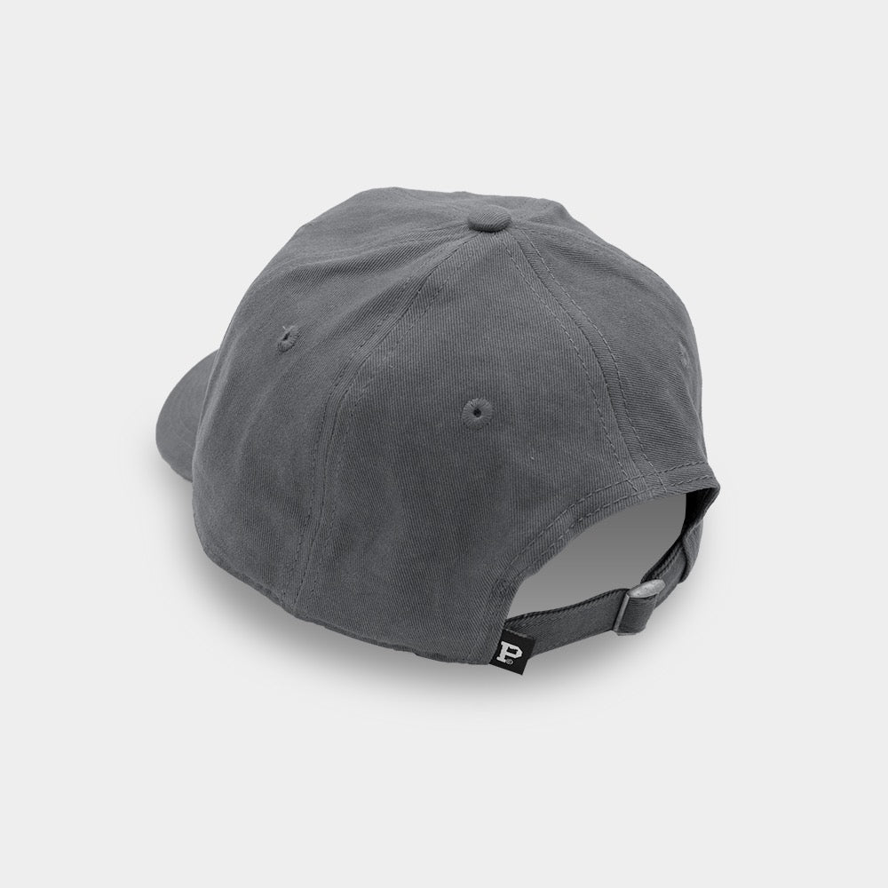 A gray Dad Hat - Classic is displayed from the back, showcasing its unstructured crown for a relaxed feel. It features an adjustable strap with a metal buckle and a small tag with the letter "P" on it. The cotton fabric looks soft and durable against the plain white background.