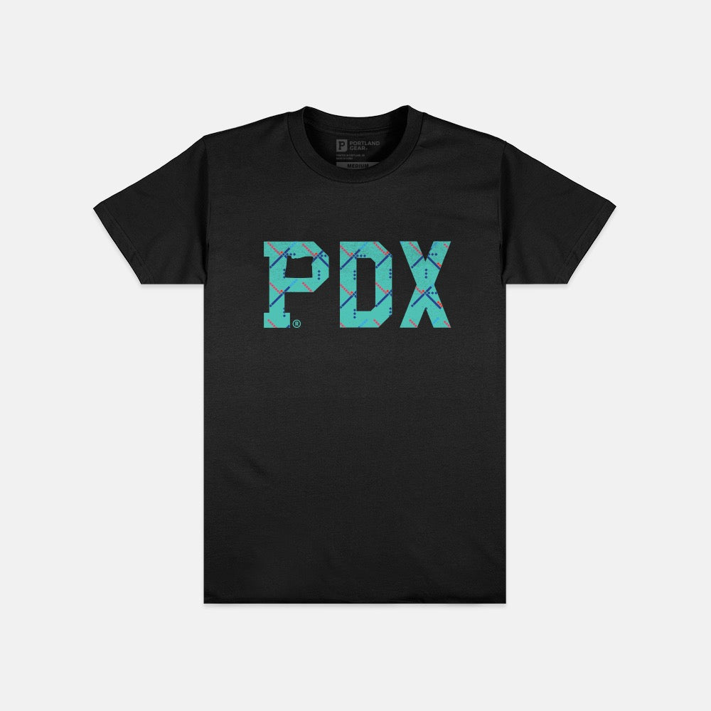 The Essential PDX Carpet Tee - Black is a limited edition featuring large "PDX" letters in turquoise with a subtle map pattern, inspired by the iconic PDX Carpet. The design is centered on the front of the shirt and comes in sustainable packaging.