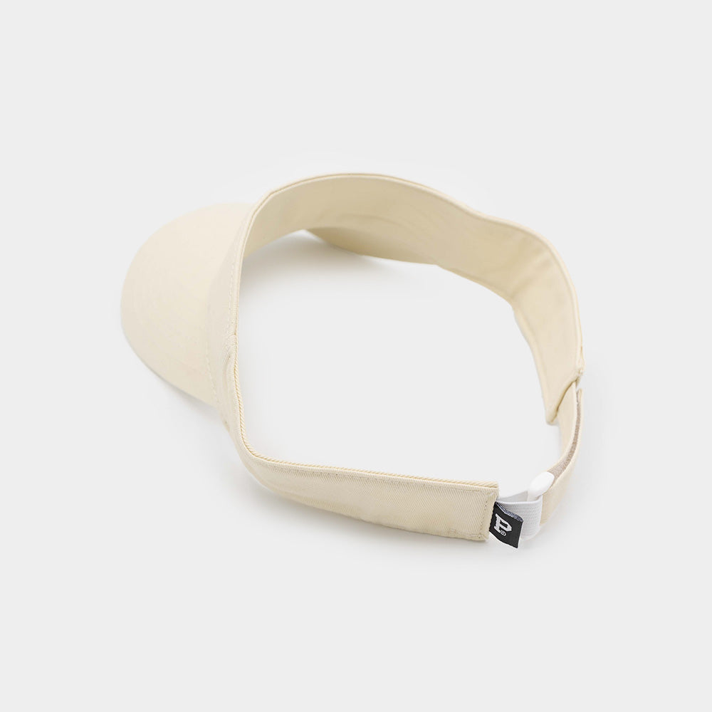 The Court Visor in beige features a structured front and an adjustable strap at the back, showcased against a plain white background. A small black tag with a white design is attached near the adjustable clasp, emphasizing its sustainable packaging.